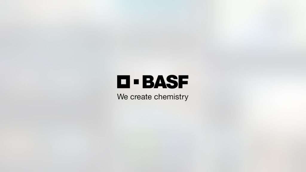 Logo des Unternehmens BASF sowie der Slogan We create chemistry auf einem verwaschenen Hintergrund